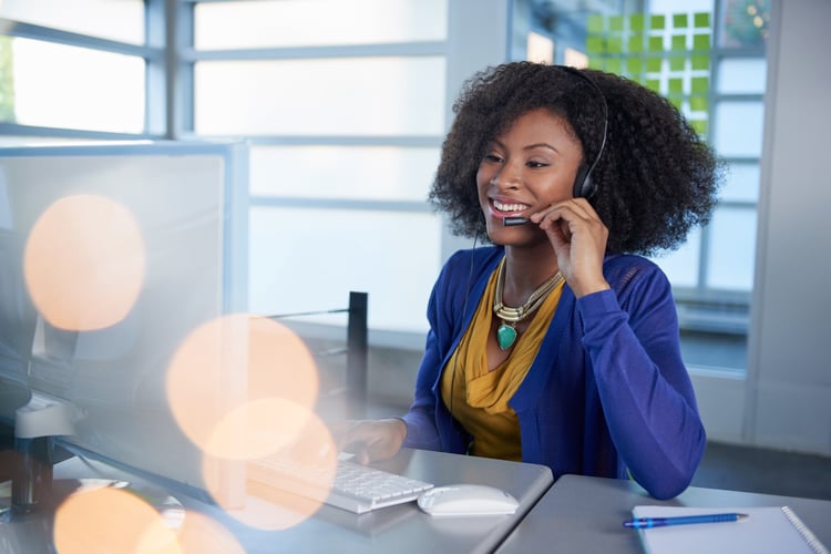 Woman on computer talking in headset to explain how to drive customer engaement 