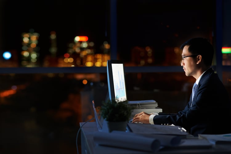 Man on computer trying to figure out how to reduce overtime 