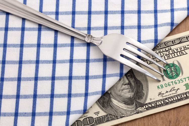 Money under tablecloth to represent how you can use checklists to cut restaurant labor costs