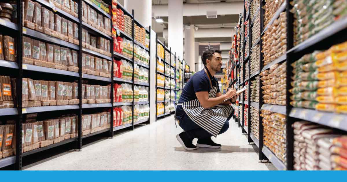 employee reviewing shelves at retail store